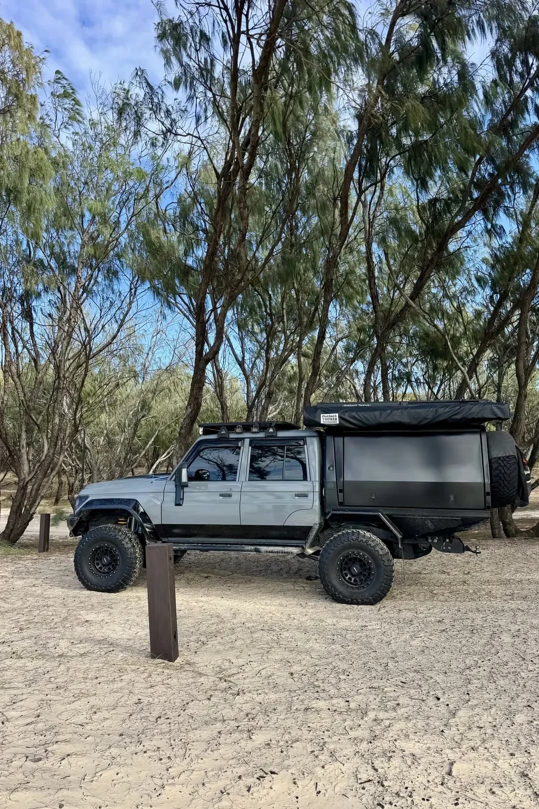 Drewsy's 79 side on at a sandy bush track, canopy and roof rack in view.